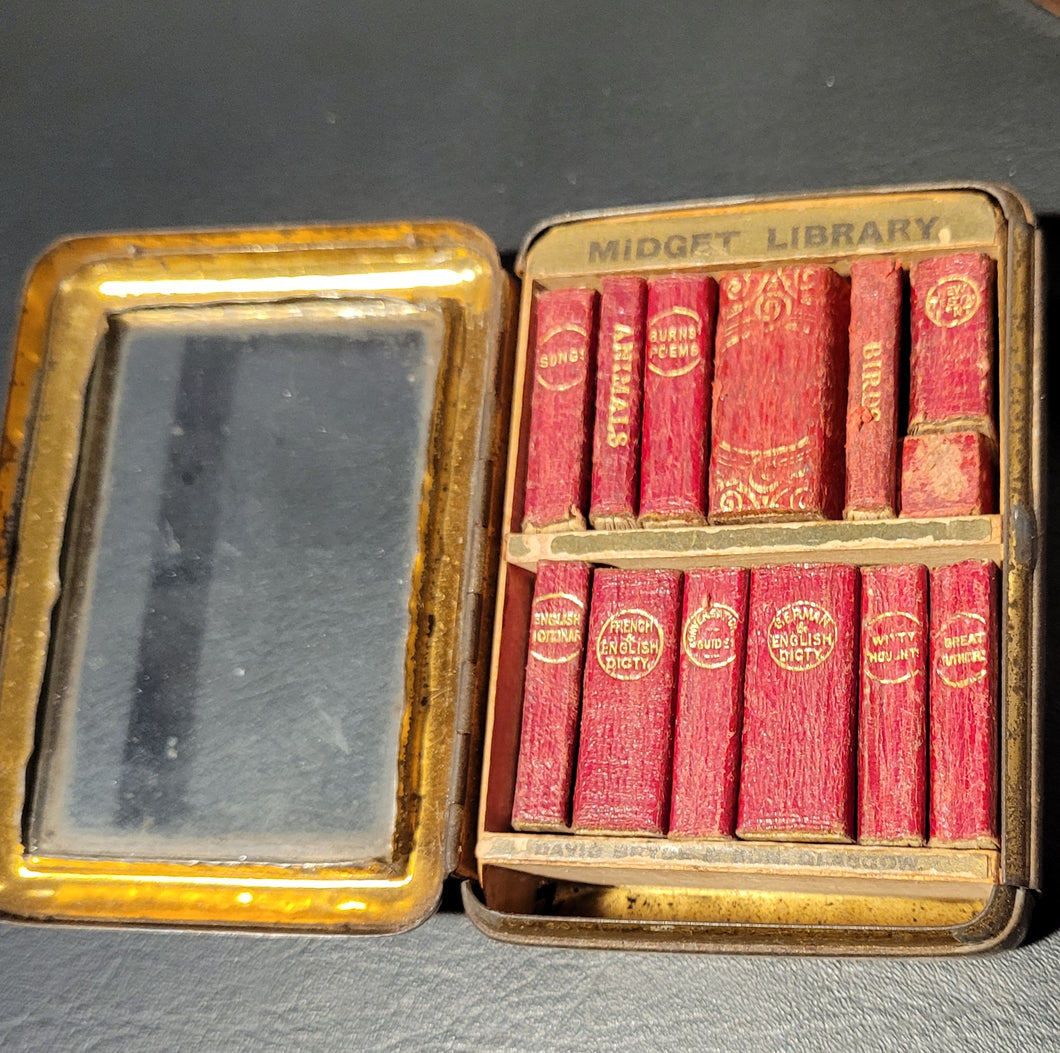 Midget Library in original Jahnckes tin, with hinged door     and fitted glass fronted case set in an angled wooden stand. Published by David Bryce & Co.